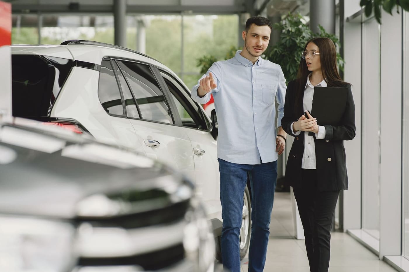 Verkoper loopt met een klant langs de auto's